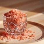 Vintage crystal glass filled with pink Himalayan salt on wooden surface